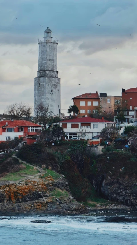 an apartment building sits on top of a hill by the ocean