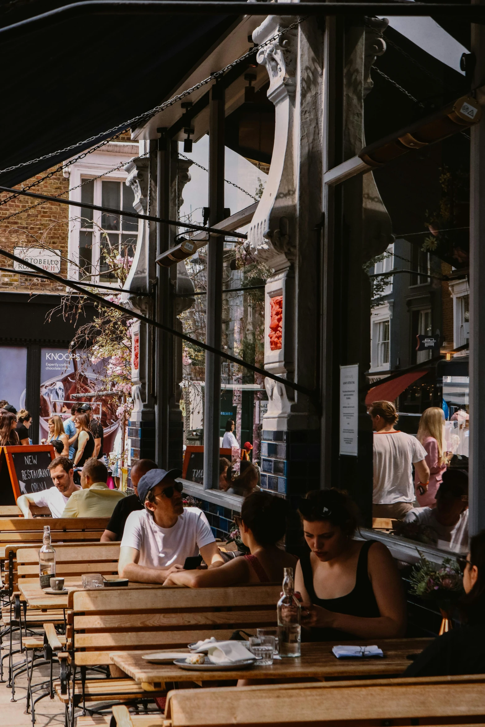 several people sitting at wooden tables in a restaurant