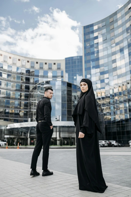 a man and woman standing outside in front of a modern building