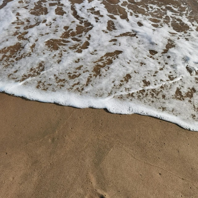 a po of water and sand in the beach