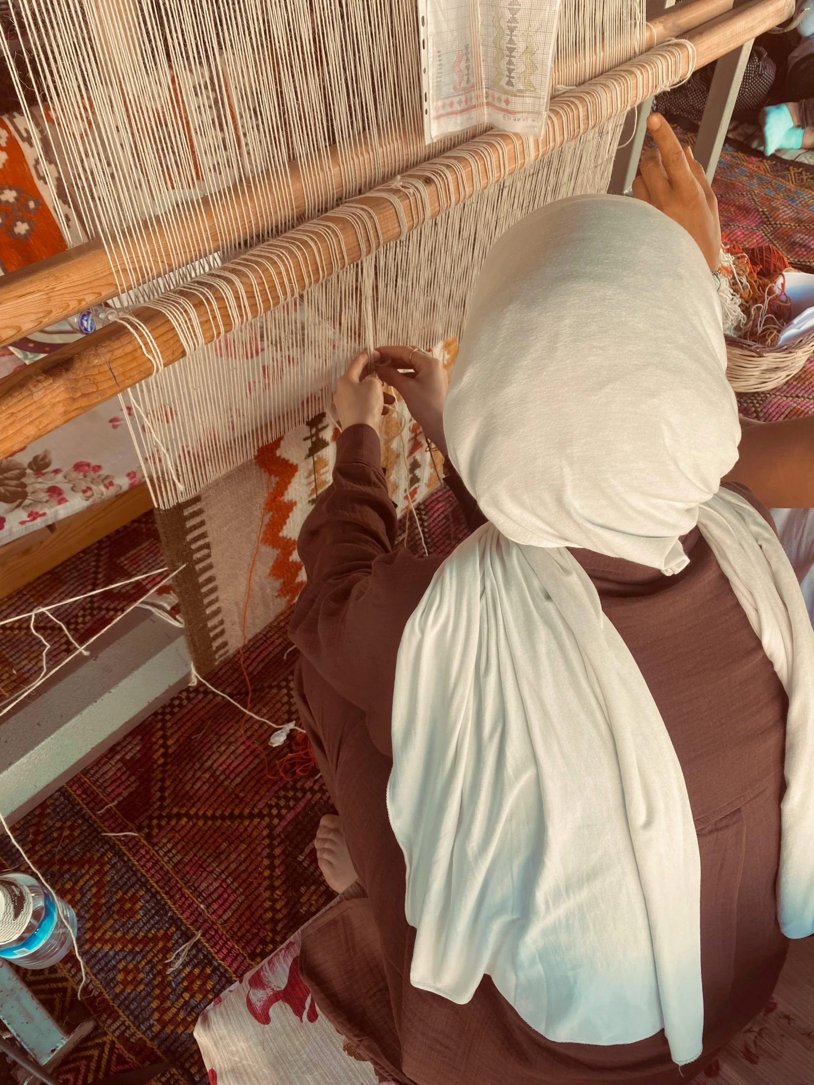 a woman sitting next to a weaving machine