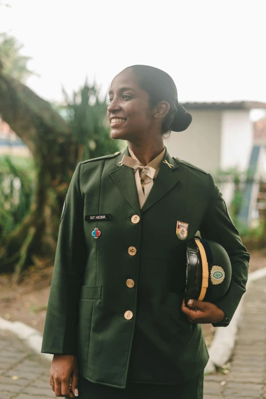 a woman wearing green uniform and smiling at the camera