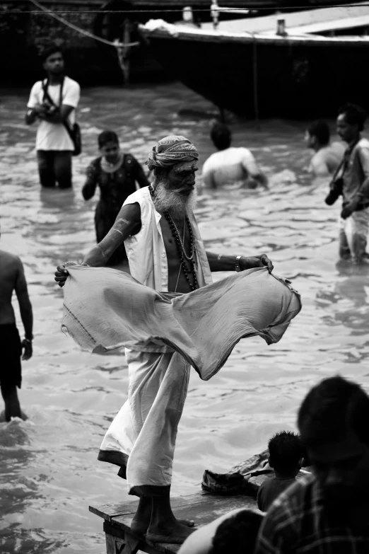 a group of people are swimming and some standing in the water