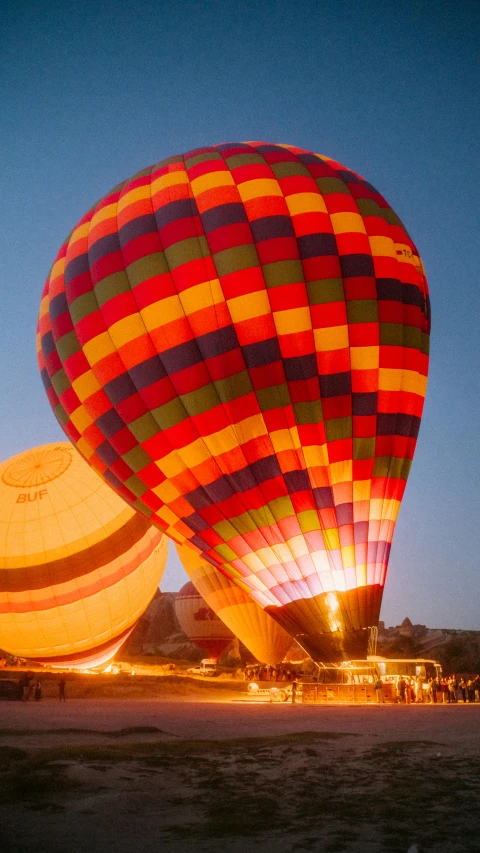 two  air balloons in the night with people looking on