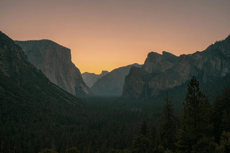 the sun is setting over some mountain tops