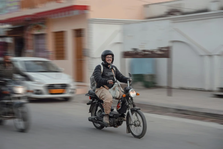 two men riding on motorcycles down the road