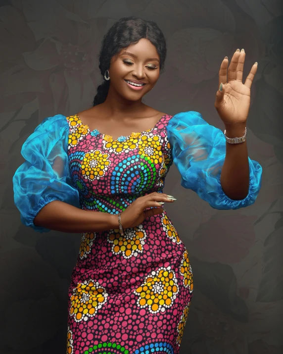 a woman wearing an african print dress making the vulcan sign