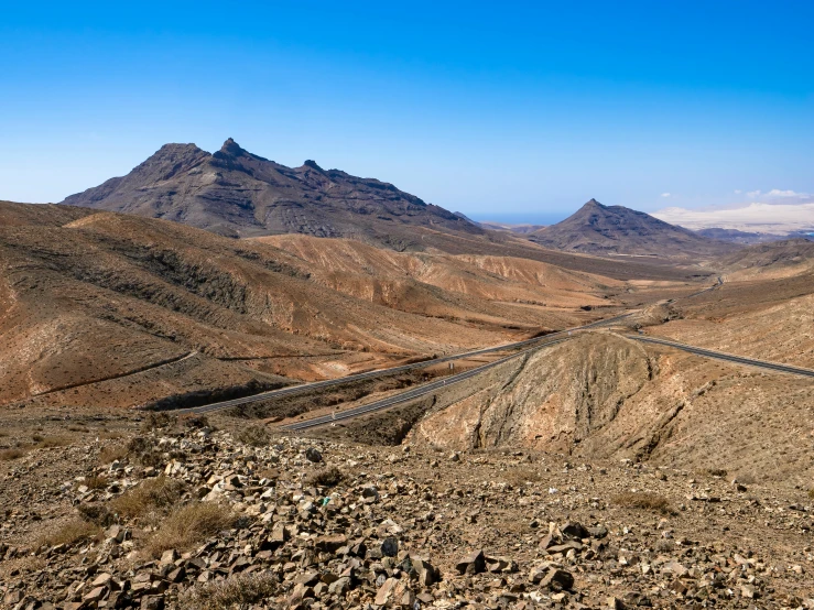 a long road with mountain in the background