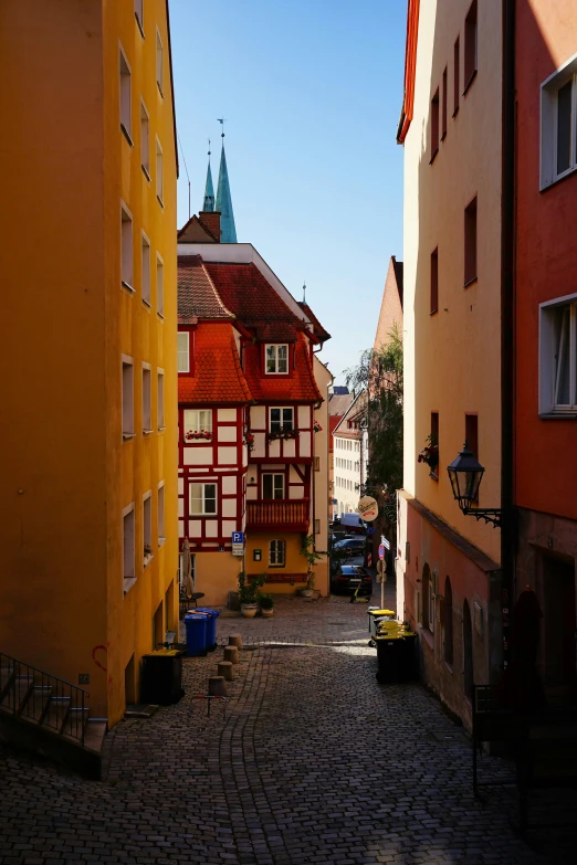 a small street is shown between tall buildings