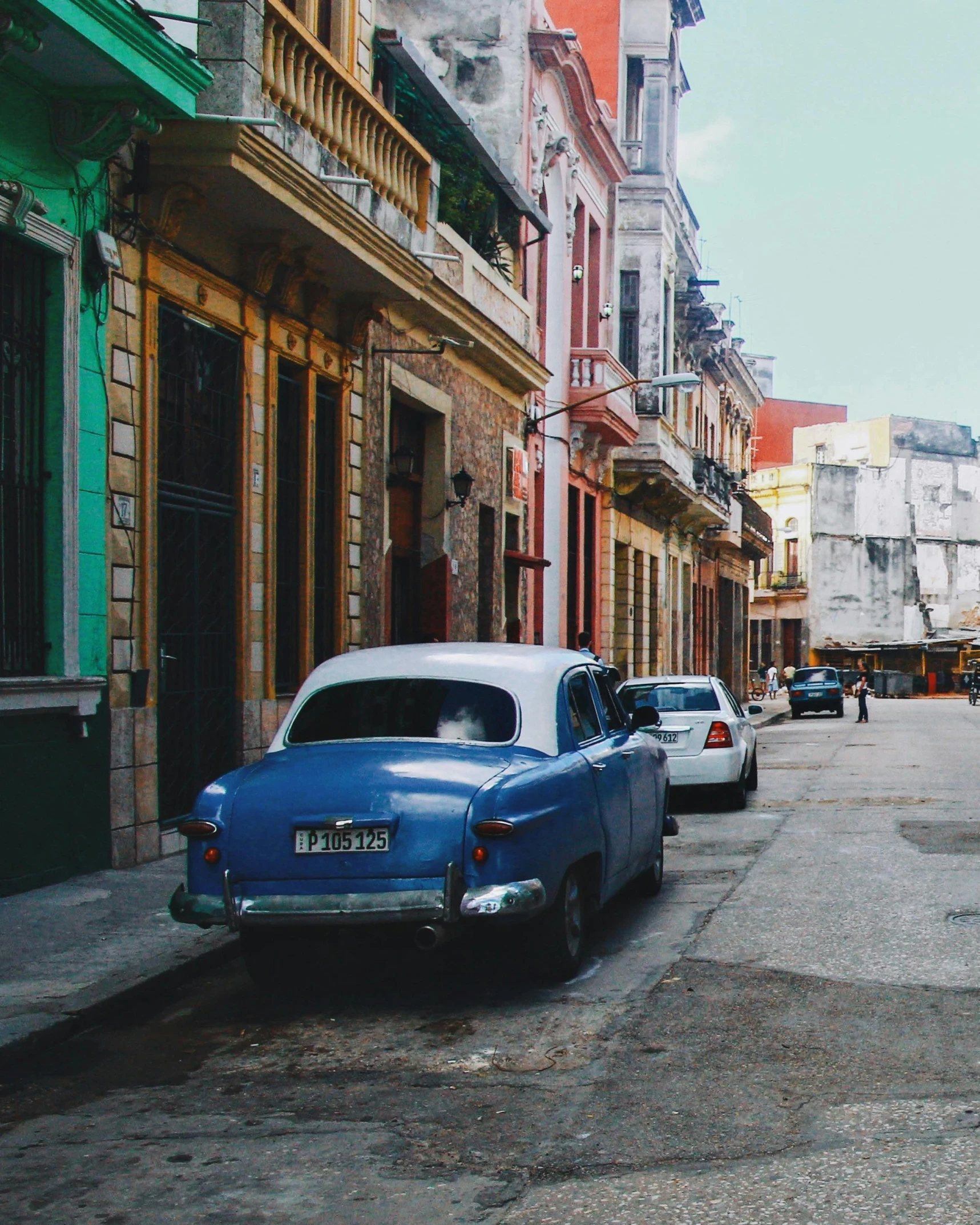 an old car is parked on the street