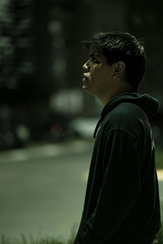 a man leaning up against a tree on a city street