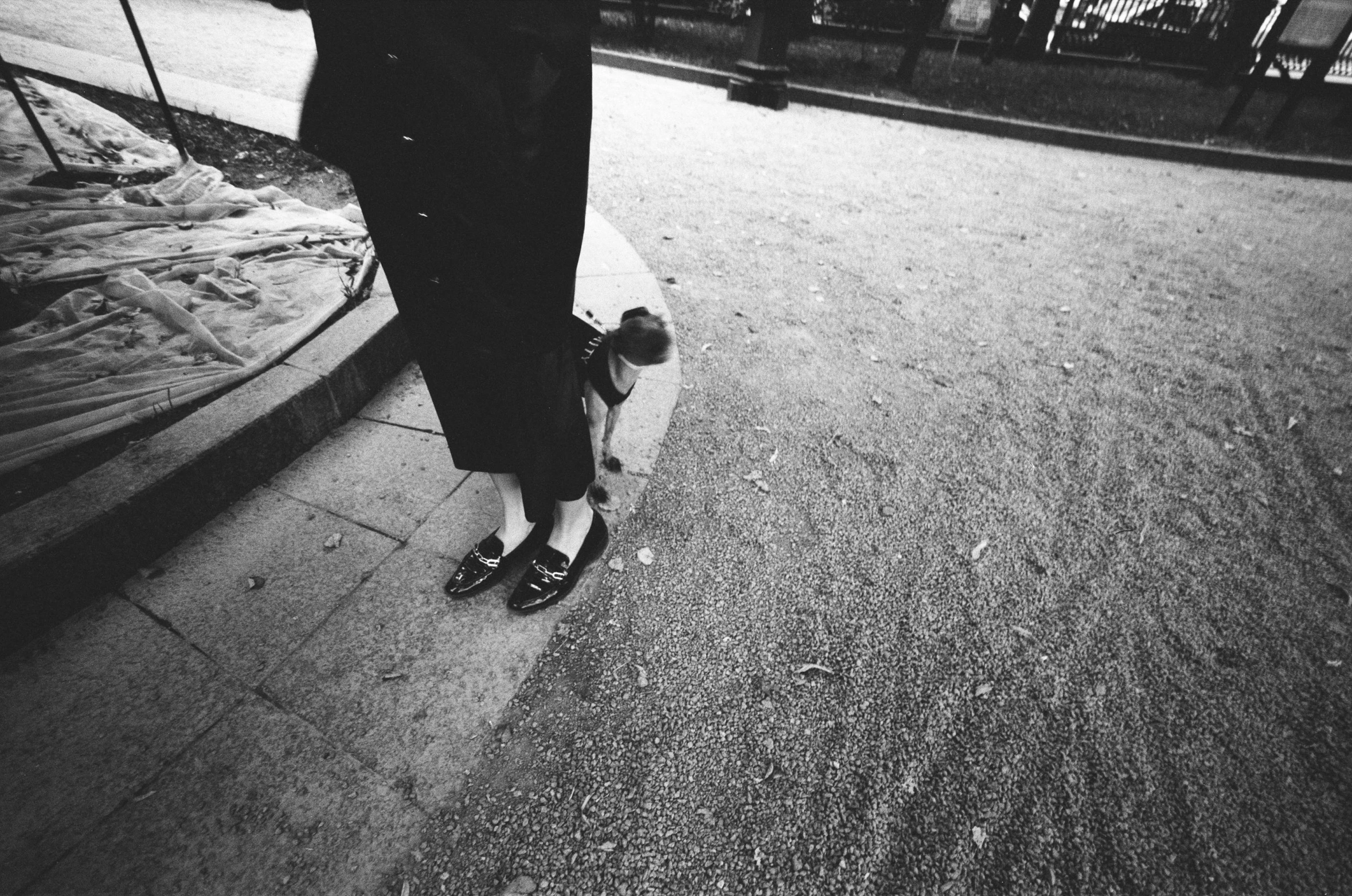 person standing on skateboard beside cement area with buildings in background