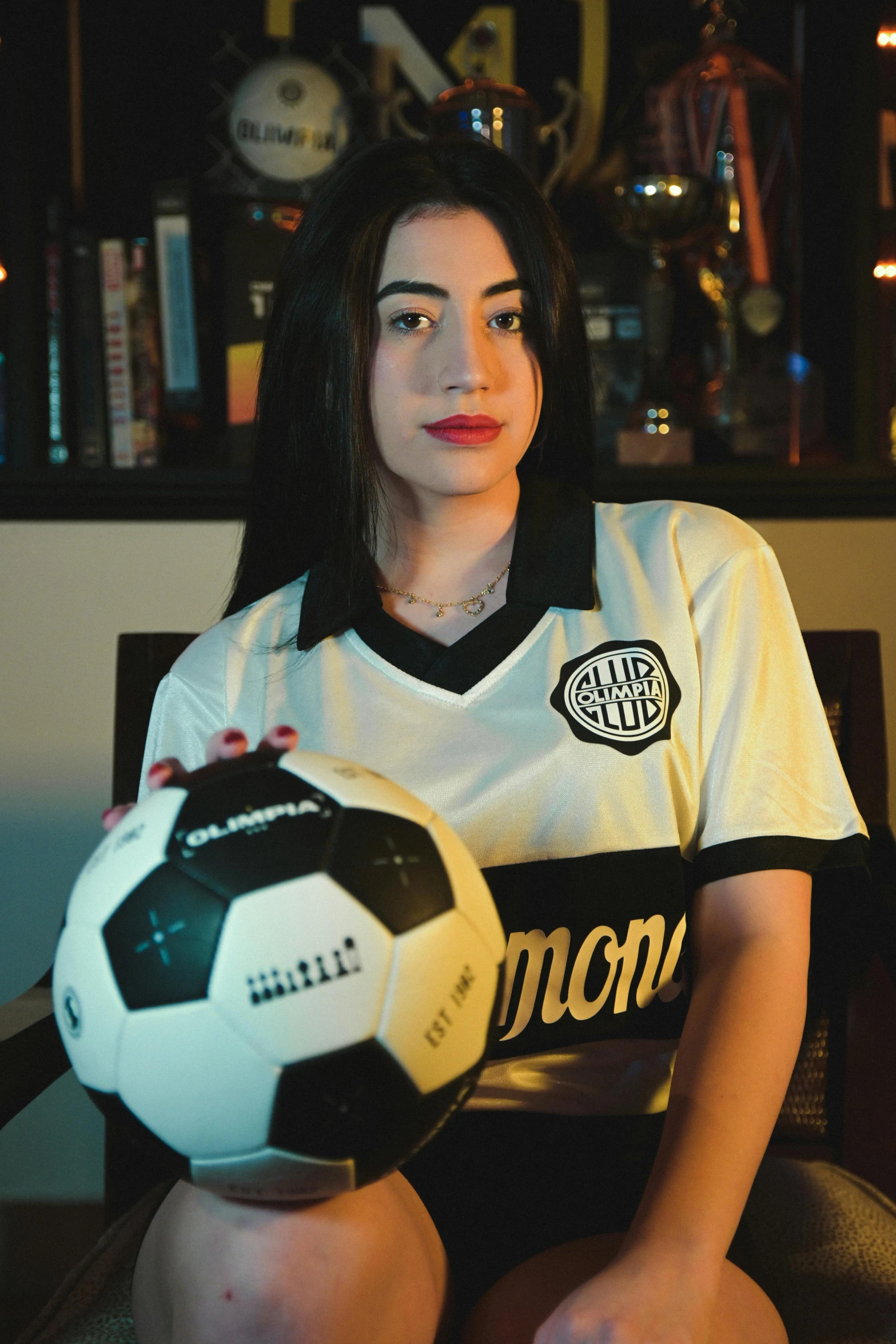 woman holding a soccer ball in the room