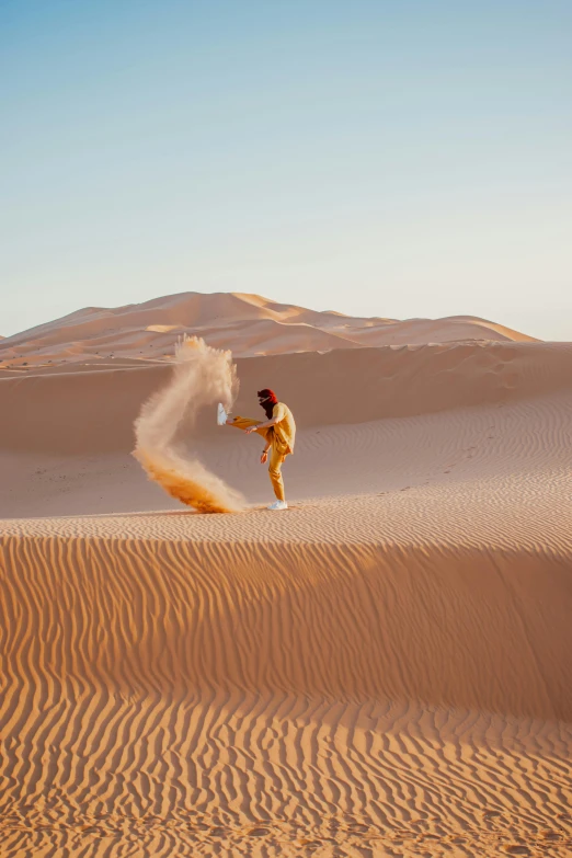 a man in yellow is spraying sand on the dunes