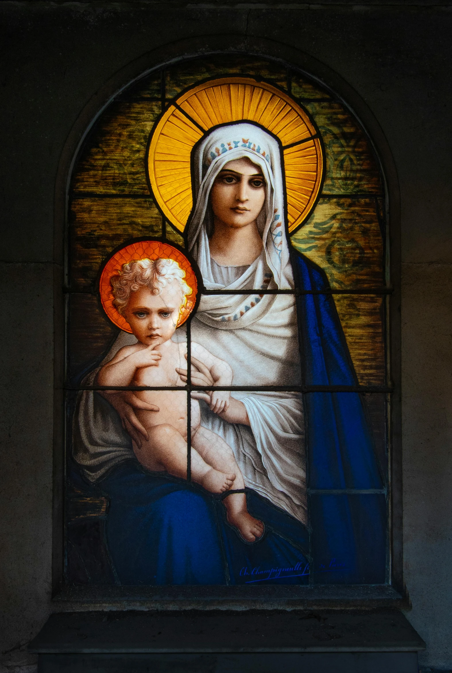 a stained glass window with a woman holding a baby