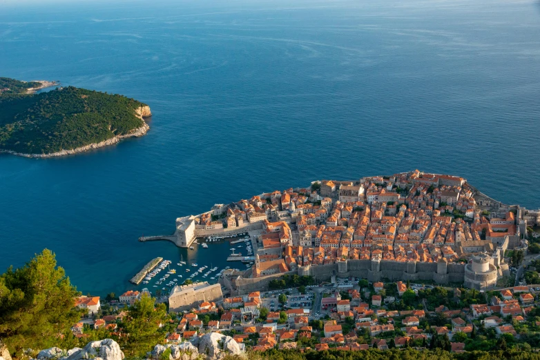 the view of a city, ocean and boat area from above