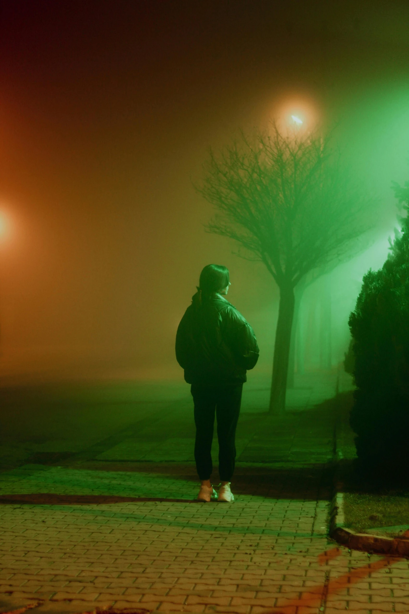 a person standing in a foggy night area with the lights off