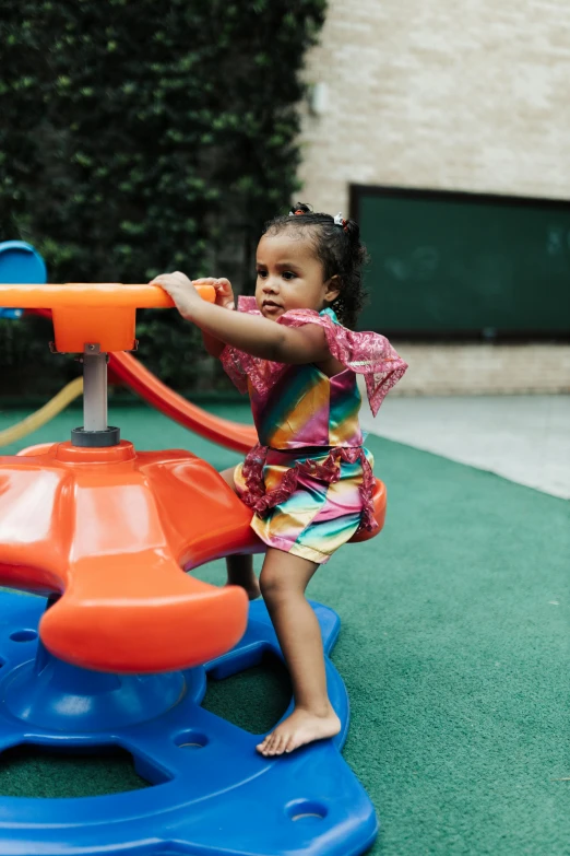 an adorable little girl hing around on a colorful toy