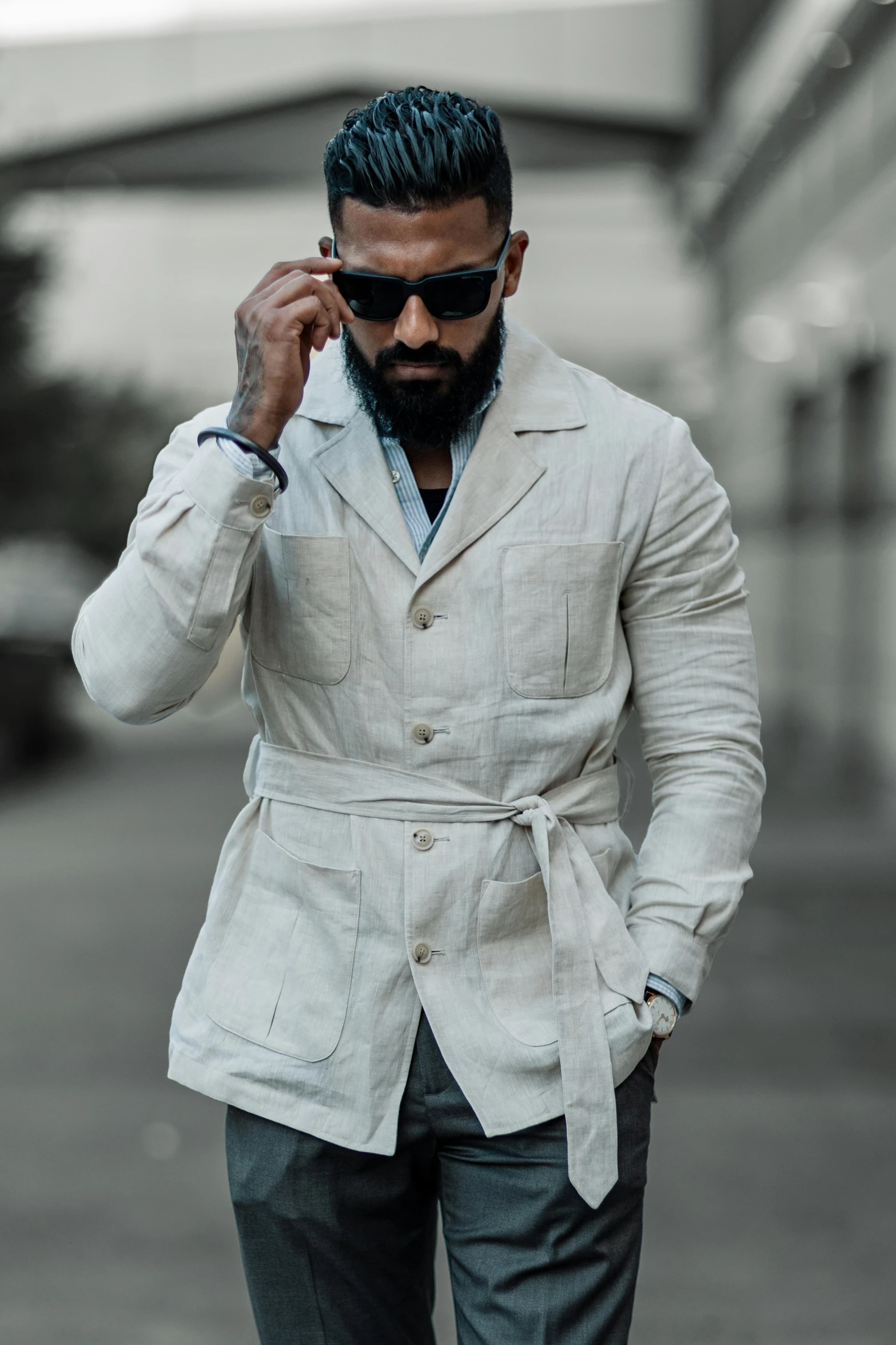 a man with a white jacket and sunglasses is walking