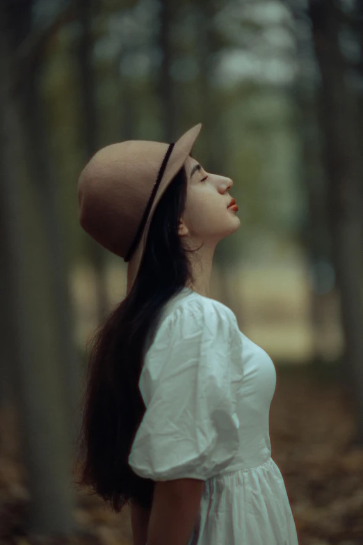 a woman wearing a hat in a forest