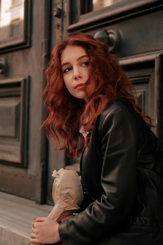 a woman with red hair holding a doll next to her