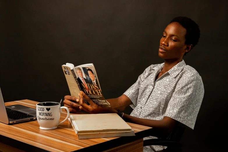 the woman is reading a book at the table