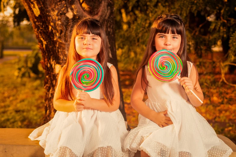 two s holding large lollipops in their hands