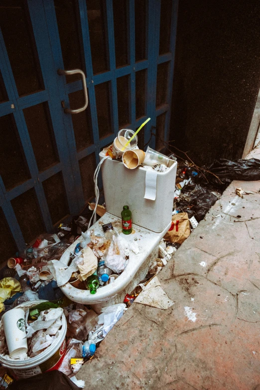 broken toilet sits on the floor of a dirty building