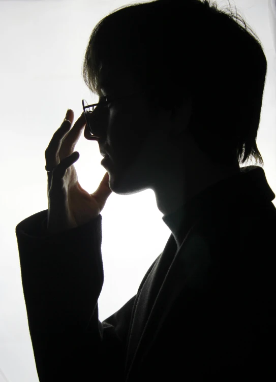 a man in black blazer with glasses looking at cellphone