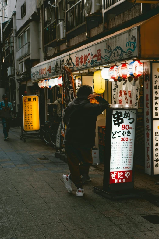 the man is standing by the food vendor