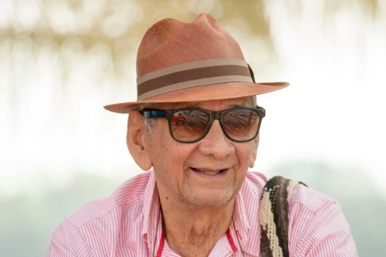 an older man with a fedora and sunglasses