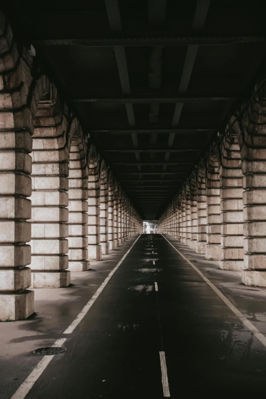 the walkway is lined with large columns, some pillars and one end