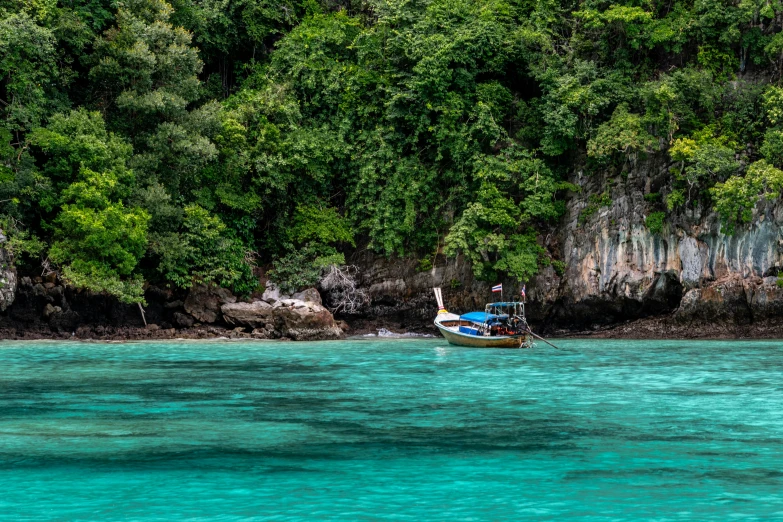 a boat floats through blue water near cliffs