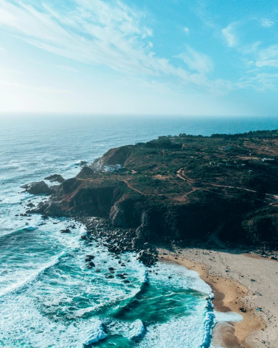 the ocean is green with blue water and rocky coast