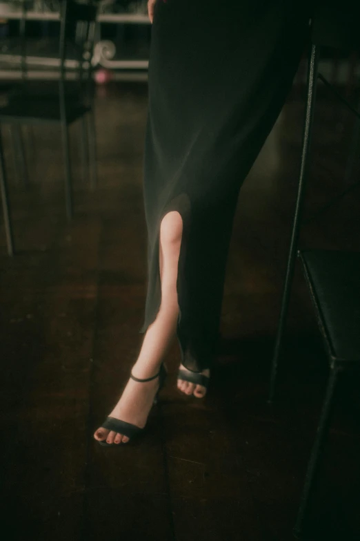 a person wearing black sandals with very high heeled shoes and white shirt