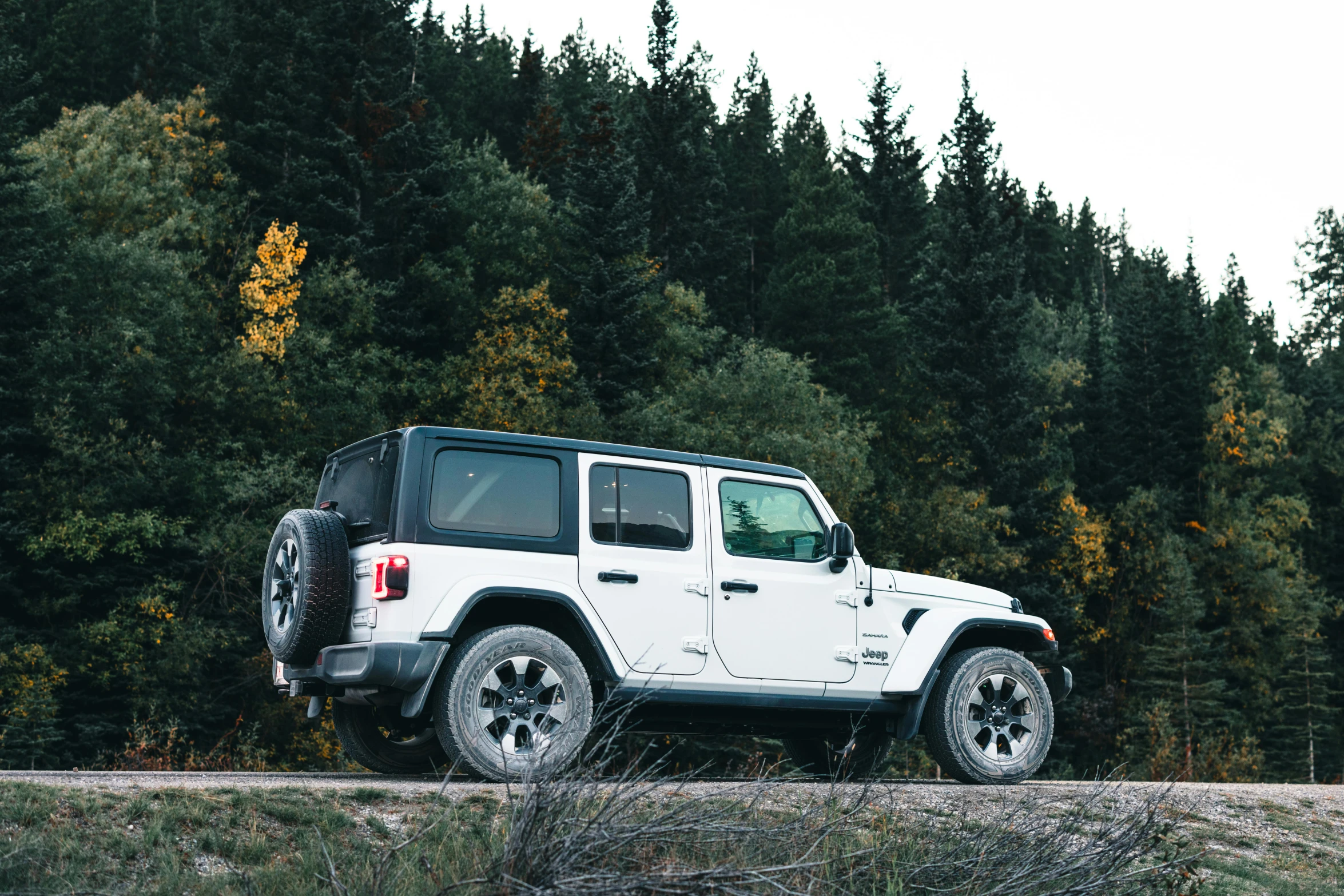 a jeep parked along side of a dirt road