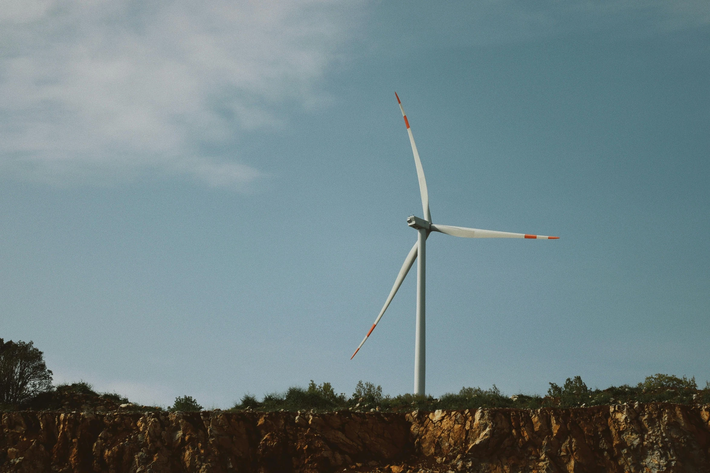 there is a wind turbine on top of a hill