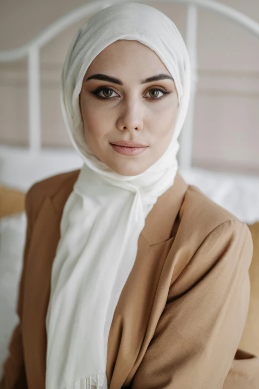 the young woman with a headscarf is wearing a brown suit