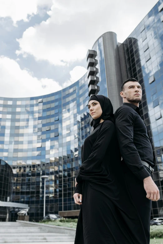 two people stand in front of a large building