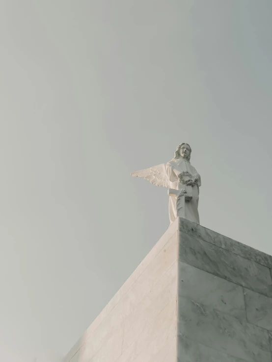 a small white statue on top of a tall building