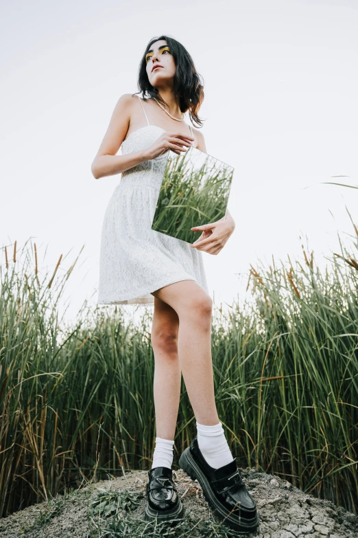 an image of a person in white dress holding grass