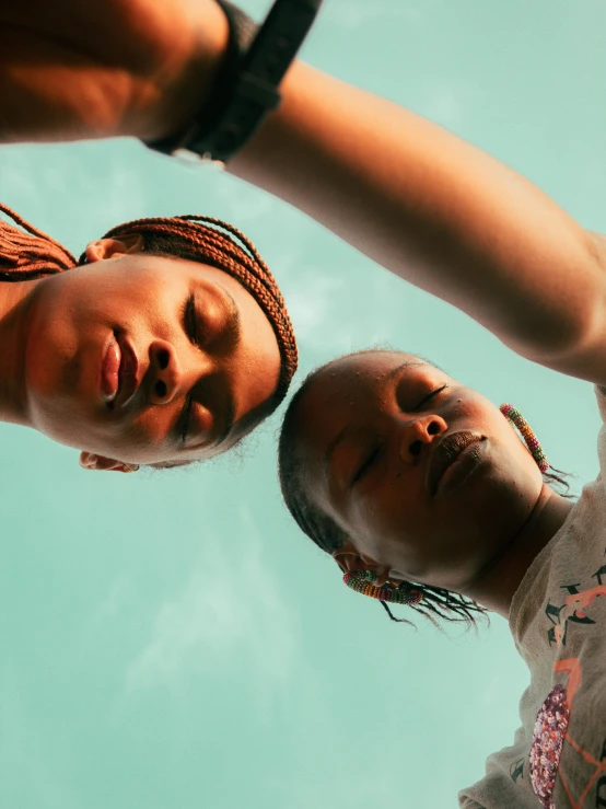 two young women standing next to each other, looking up