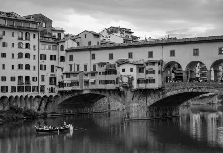 a boat is on the water under a stone bridge