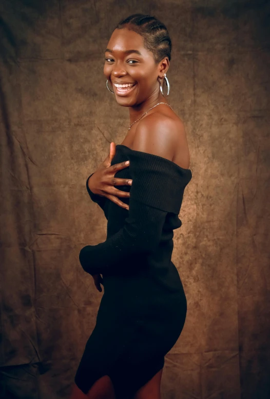 a black woman poses for a po with her arms crossed