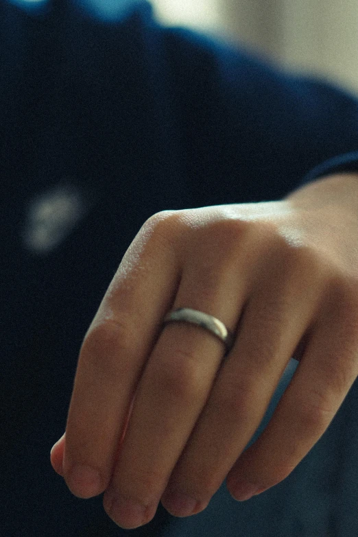the hand that is holding a small ring in their left hand