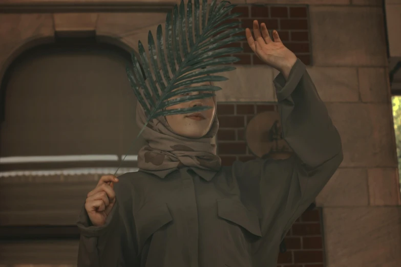 a young woman wearing a hijab with a fern plant headpiece