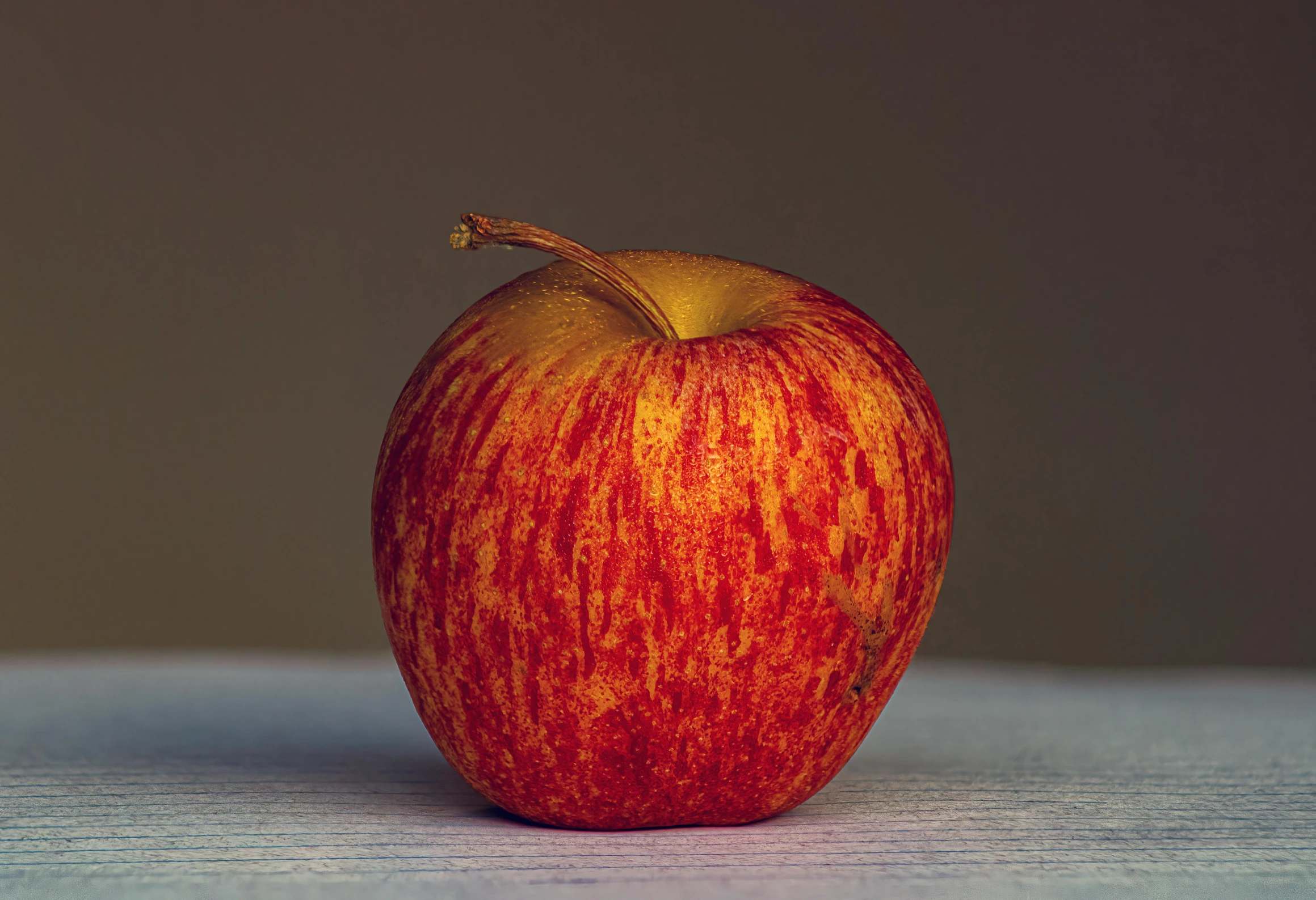 a very colorful apple sitting on the table