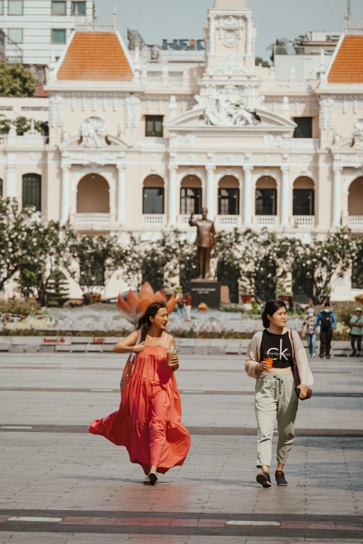 two people are walking along a city plaza