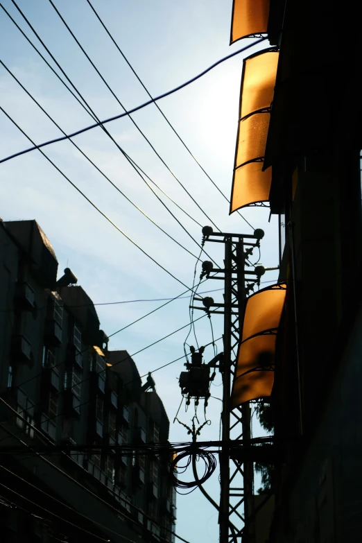 the back of a building with a bunch of electrical wires above it