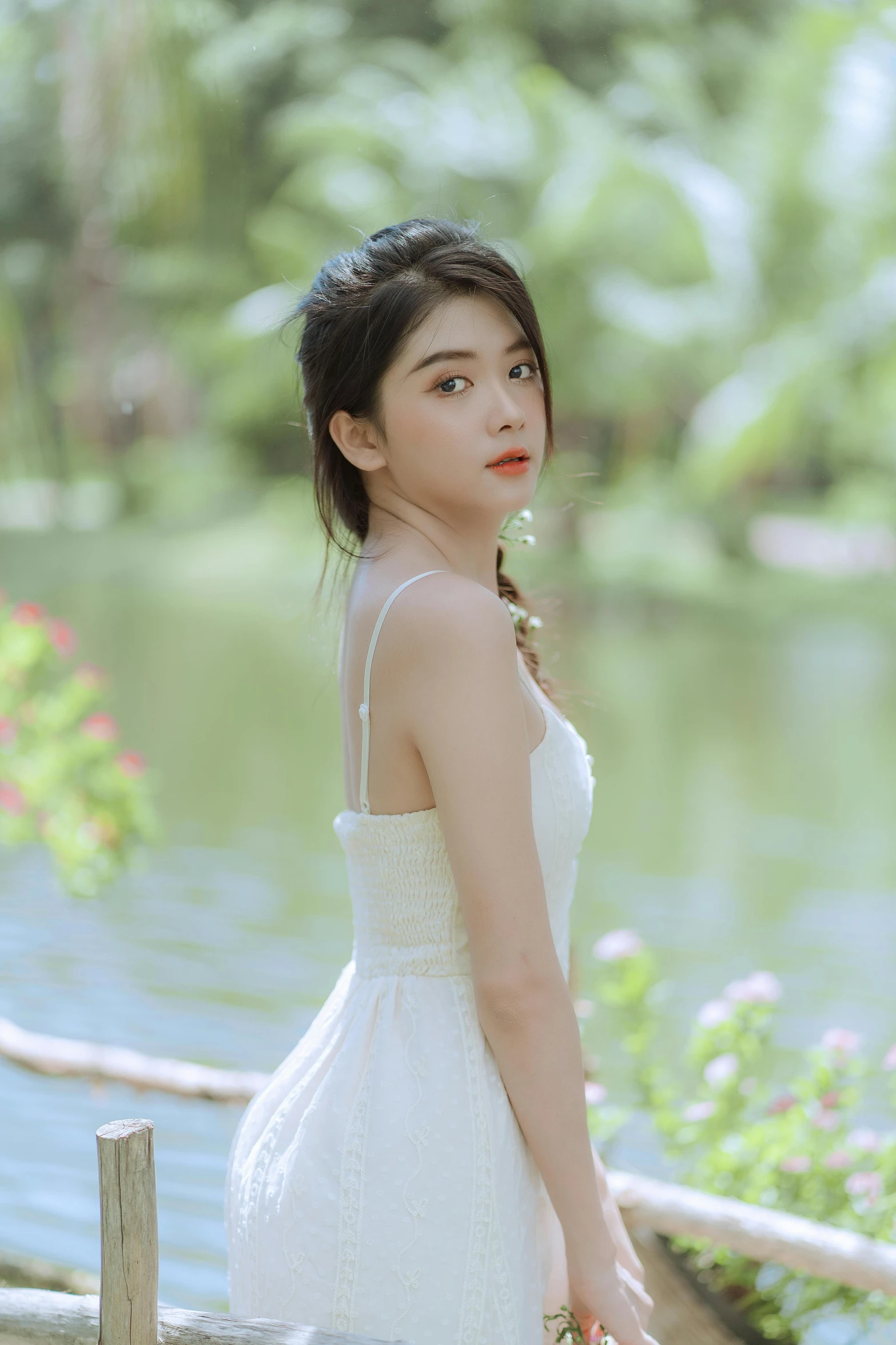 an asian woman in white and holding a pink floral bouquet